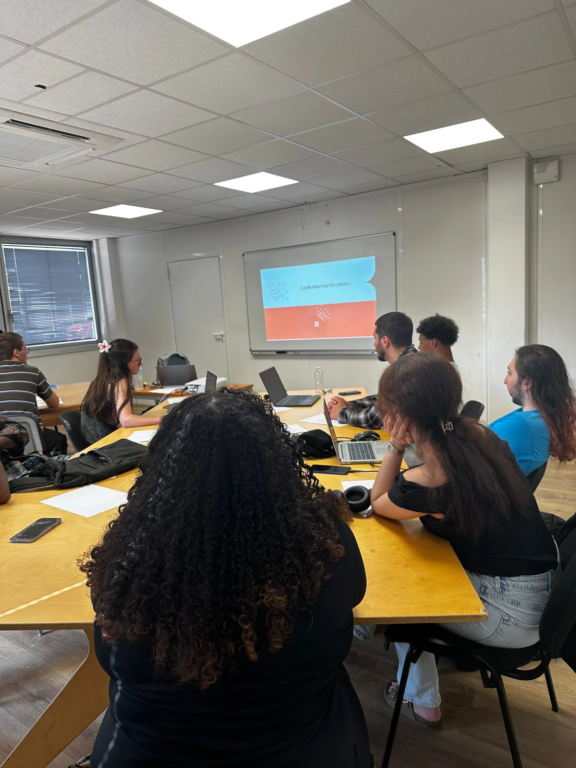 Apprentis du CFA Paedagogia à Toulouse en cours de formation, suivant une présentation projetée dans une salle de classe.